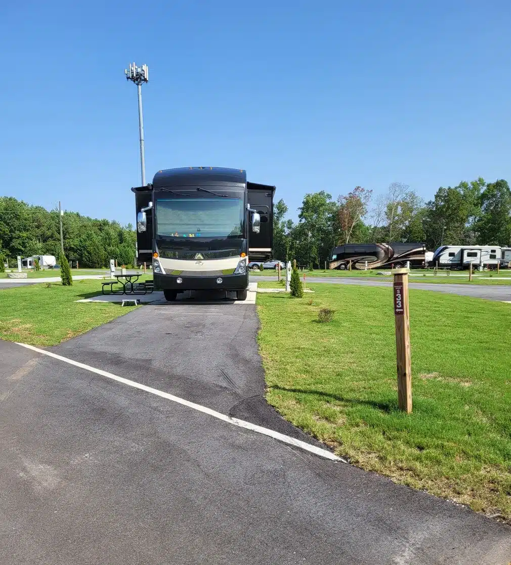 Aerial view of RV sites at Atlanta South RV Resort, featuring concrete pads, green spaces, and wooded surroundings.