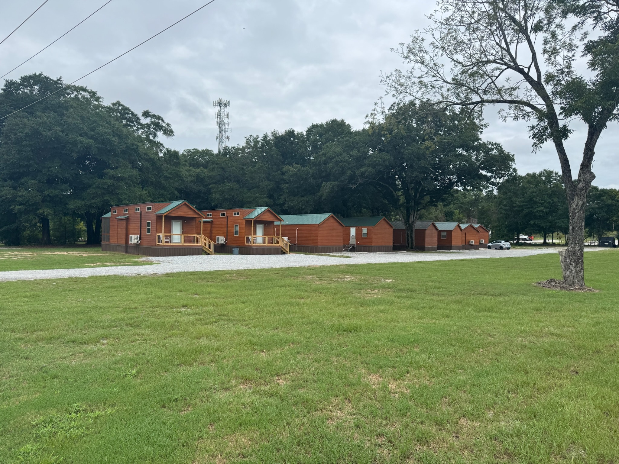 Cabin accommodations across a grassy area at Camp David RV Resort