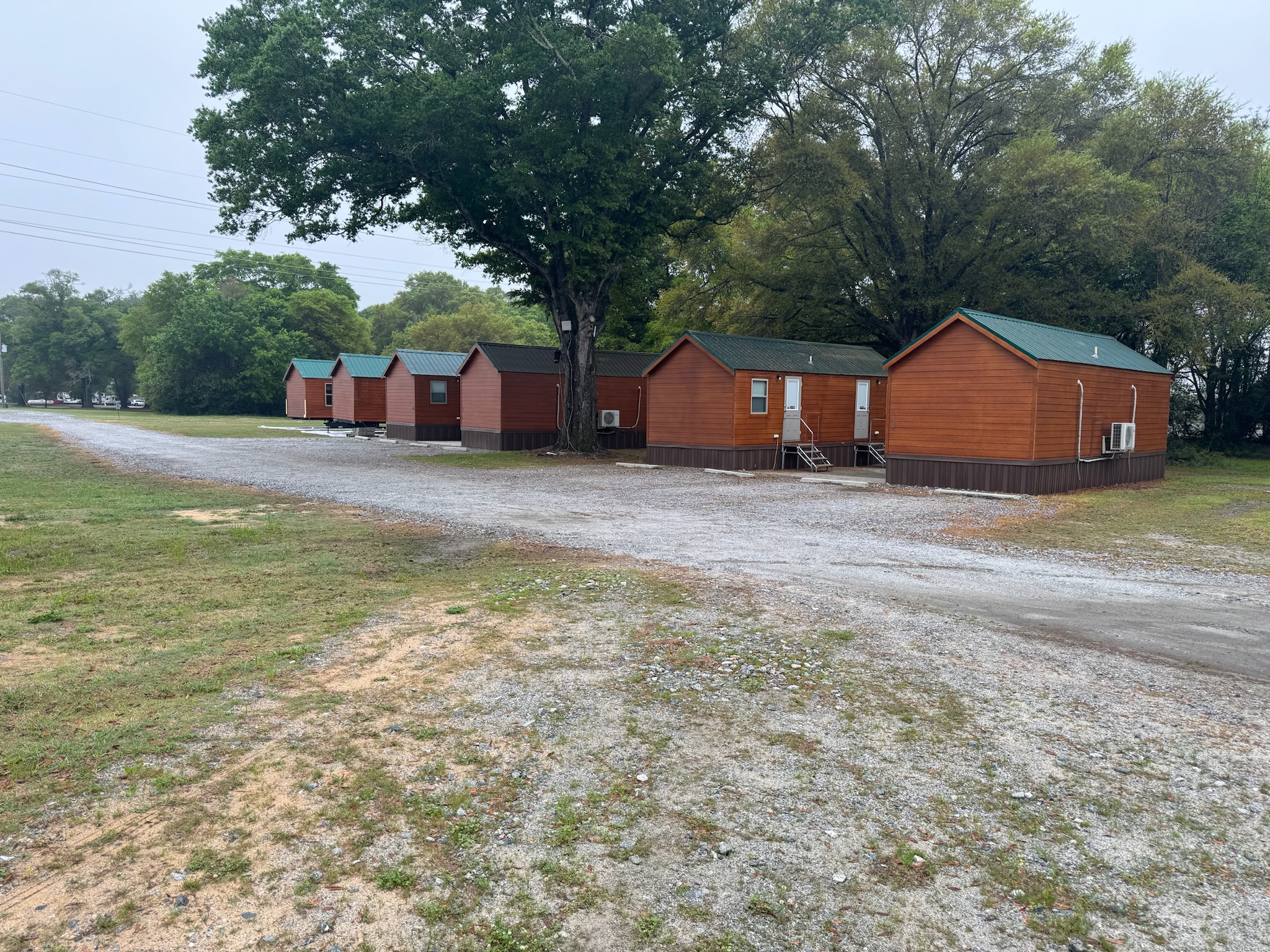 Row of wooden cabins with green roofs at Camp David RV Resort