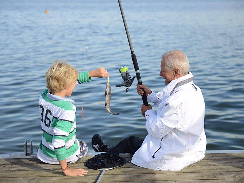 Camper fishing at Lake Wren's 25-acre pond and dock at Camp David RV Resort