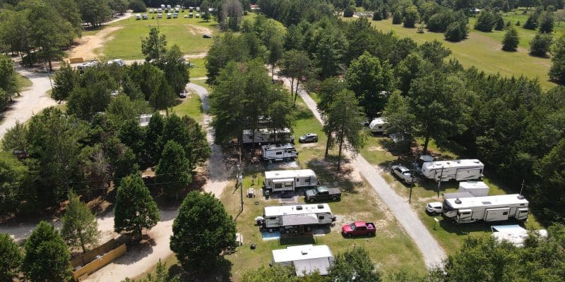 Aerial view of RV campsites and wooded grounds at Jellystone Park Cochran