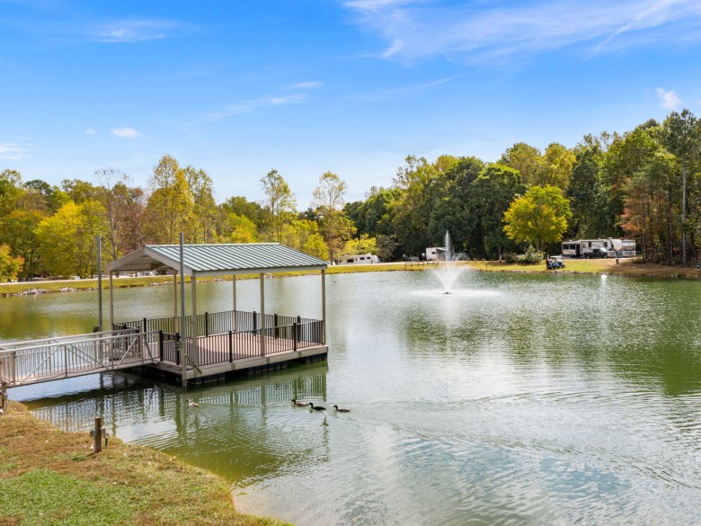Covered fishing dock, fountain, and ducks at Leisure Acres RV Resort
