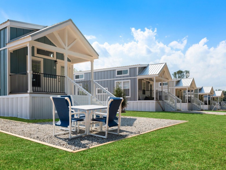 Riverside cabins with covered porches at Winding Waters Riverfront RV Resort